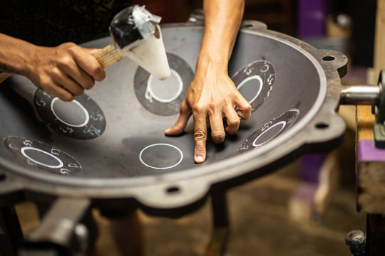 Hands designing handpan in a workshop
