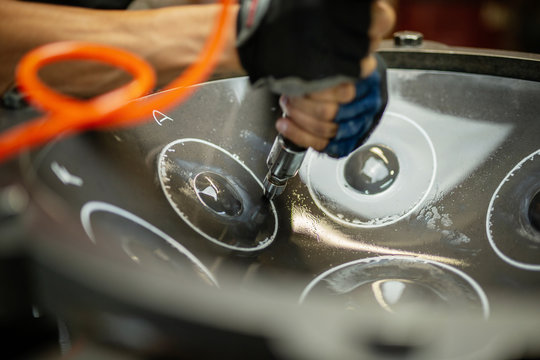 Artisan constructing handpan with hammer