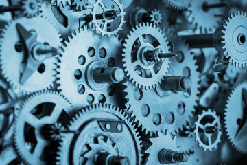 Gears and cogs macro in vintage old mechanism blue toned