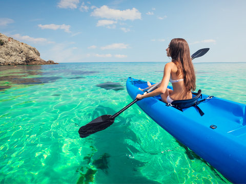 Young woman kayaking in the sea.