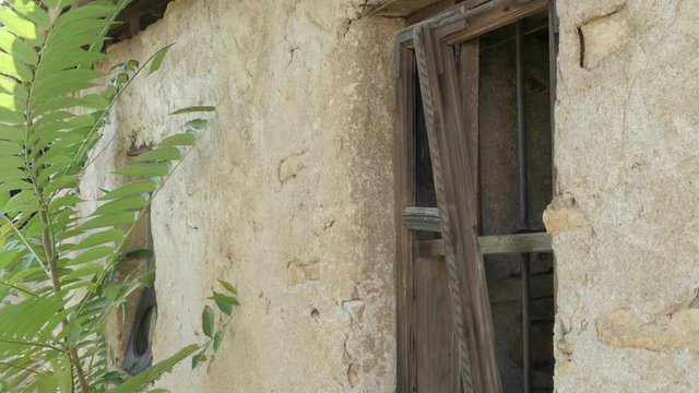 Mud house with broken windows slow tilt 4K footage