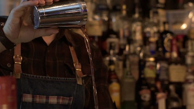 Bartender prepare alcoholic coctail in modern bar. Slow motion