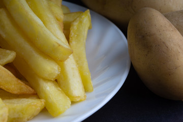 Potato fry on dark background with selective focus and crop fragment