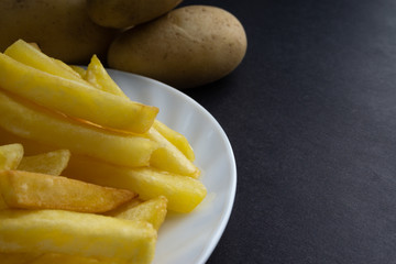 Potato fry on dark background with selective focus and crop fragment