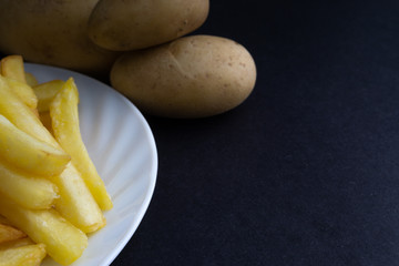 Potato fry on dark background with selective focus and crop fragment