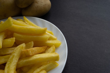 Potato fry on dark background with selective focus and crop fragment
