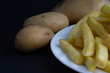Potato fry on dark background with selective focus and crop fragment
