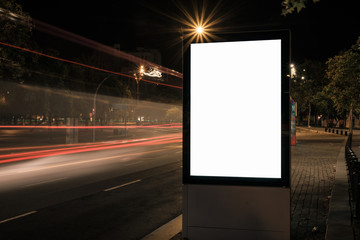 Light box display with white blank space for advertisement. Mock-up design concept with beautiful car light trails at night. Long exposure.