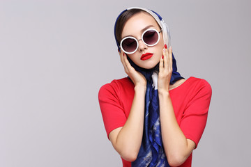 Young woman in retro style. Sunglasses and silk scarf.