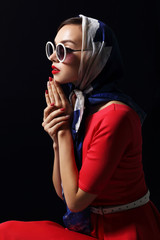 Young woman in retro style. Sunglasses and silk scarf.