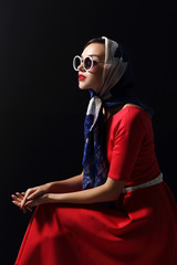 Young woman in retro style. Sunglasses and silk scarf.
