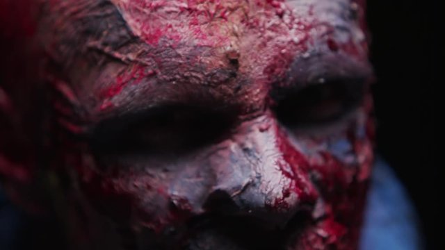 Zombie Maniac is scary of his teeth trying to bite the dark background of darkness