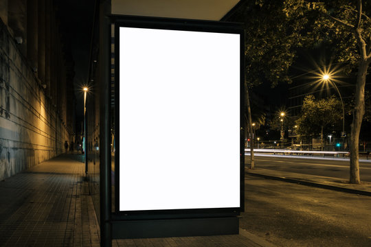 Light box display at bus stop in night city. White blank space for ads. Marketing concept. Horizontal mock-up.