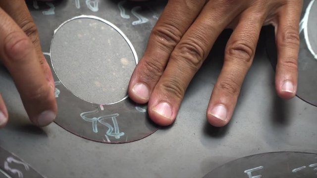 Artisan hands designing Handpan in his workshop, a metal percussion instrument.