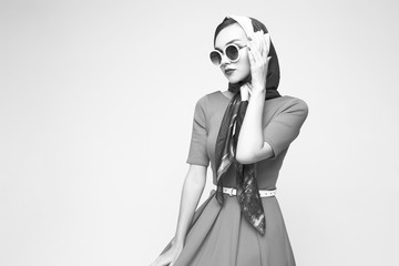Young woman in retro style. Sunglasses and silk scarf.