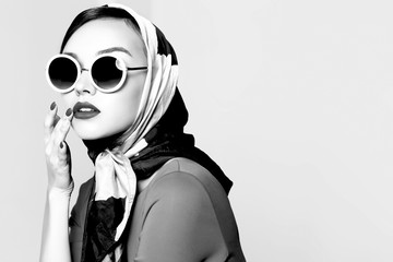 Young woman in retro style. Sunglasses and silk scarf.