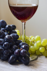 red wine with grapes close on the table