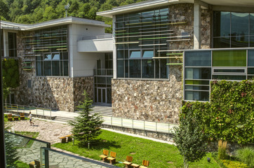 Garden with benches, fountain in the yard between the educational buildings of the International College, in Dilijan,in a reserved forest

