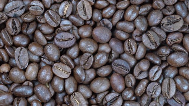 Fried coffee beans background, close up, rotation loopable 4k top view. Food  background. Gastronomy concept, organic food. Macro coffee beans