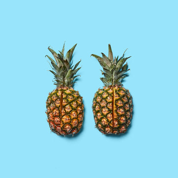 Pineapple with green leaves cut into pieces presented on a blue background with space for text. Creative layout for your ideas. Flat lay © artjazz