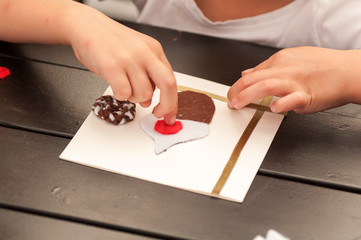 child glues a card with felt figures, master class