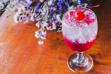 Close up Strawberry Italian soda with cherry,Bouquet of dried flowers background.