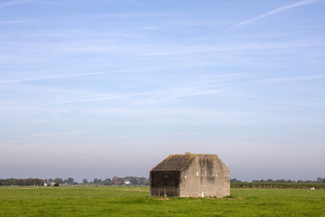 Obraz premium Bunker, concrete fortification of the second world war, in a meadow in the Dutch landscape.