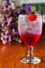 Close up Strawberry Italian soda with cherry,Bouquet of dried flowers background.