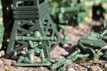 plastic toys. figures of small green armed soldiers fighting each other.