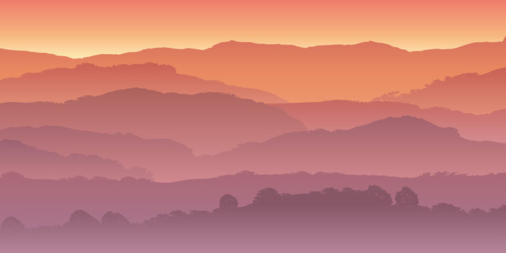 Paysage de montagne dans la brume, coloré par le soleil couchant