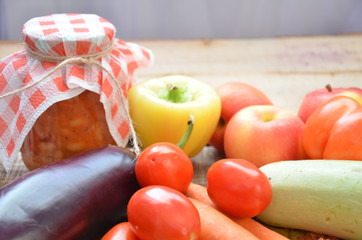 Jars of pickled vegetables and fruits in the garden. Marinated food. bank home lecho. canned vegetables autumn harvest. Eggplant, sweet peppers, tomatoes.