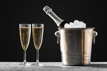 glasses of champagne with a champagne bottle in a bucket - obrazy, fototapety, plakaty