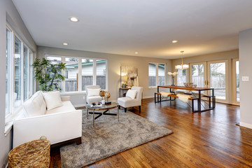 Living room in neutral colors with hardwood floor.