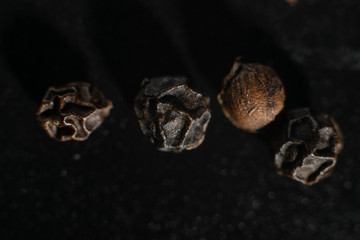 Macro photo of black pepper peas on a black background