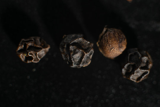 Macro photo of black pepper peas on a black background © barindos