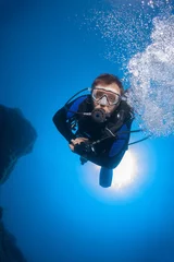 Foto auf Glas Scuba diver underwater in the deep blue ocean and backlight sun. © frantisek hojdysz