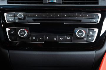 Media and navigation control buttons of a Modern car. Car interior details. White leather interior of the luxury modern car. Modern car interior