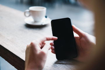 Woman holding a smartphone and pointing at screen with her finger