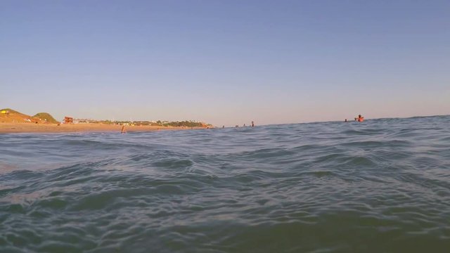 Shooting from sea, sunset and waves cover camera. Portugal Algarve.
