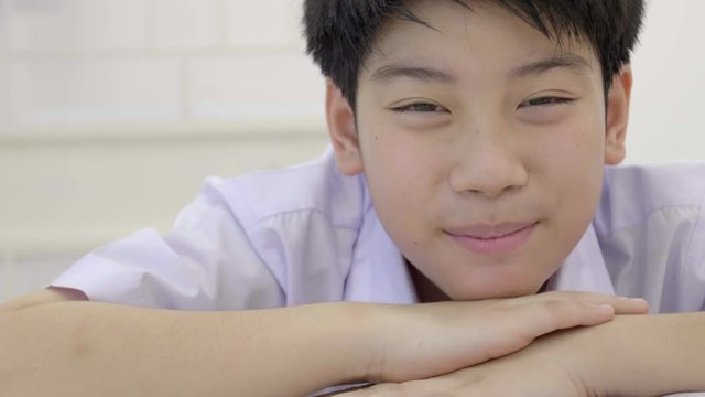 Portrait of asian child in student uniform looking at camera with smile face . 4K Slow motion of THIALAND cute boy is smile.