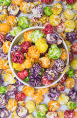 a bucket of multi-colored popcorn in the background, scattered sweet dessert