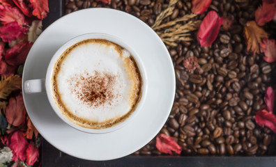 Cup of cappuccino coffee on wooden table.