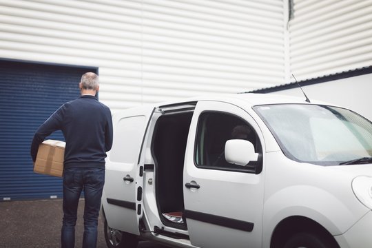 Delivery man carrying parcel at warehouse