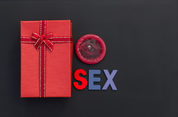 Red gift box ,condom on stone background. Safe sex concept.