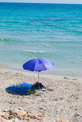 Fototapeta na wymiar Blue and beach towel close to the sea of Menorca