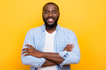 Portrait of handsome cheerful nice mulato man in shirt, folded a