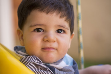 Beautiful brazilian baby boy looking at camera. baby on the swing. Happy baby.