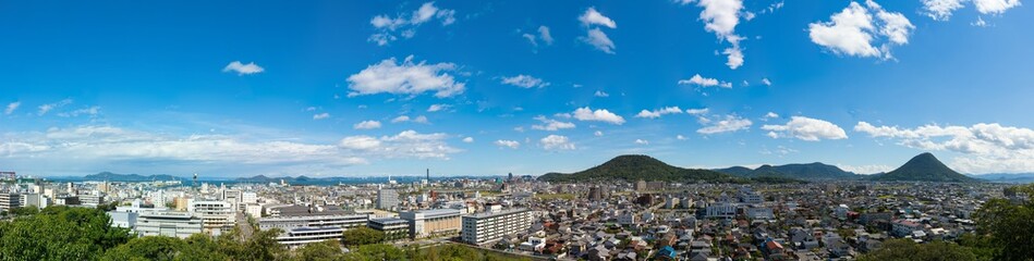 Fototapeta premium 丸亀城から見るパノラマ風景(香川県丸亀市～宇多津町街並み、遠方に瀬戸大橋、飯野山)