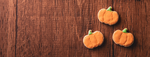 Fresh delicious homemade decorated halloween cookies sweets on dark wooden background, concept of halloween party, copy space(text space), top view, blank for text.
