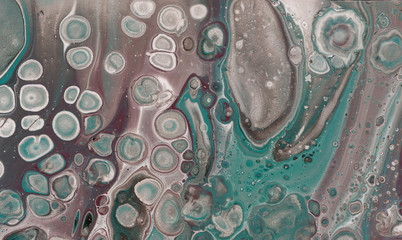 Beautiful textural background. A rich emerald paint flowing in maroon and brown with the addition of black and white paint. The style includes curls of marble or agate ripples with bubbles and cells. 